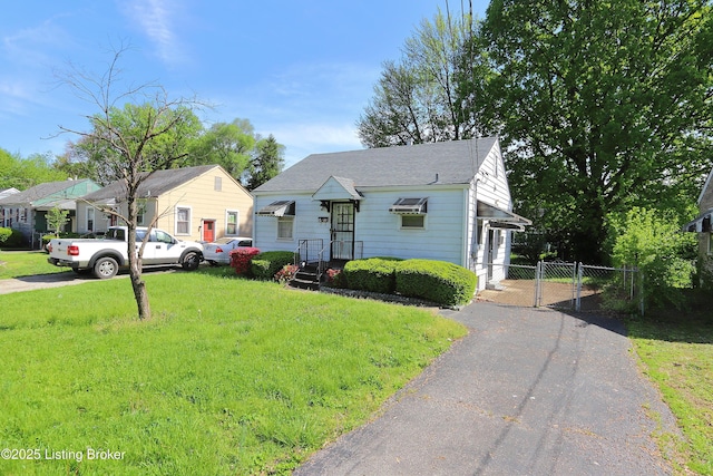 bungalow-style home with a front lawn, a shingled roof, a gate, aphalt driveway, and fence