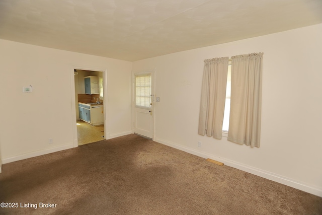 unfurnished room featuring baseboards and carpet