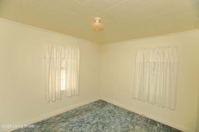 spare room with carpet flooring, baseboards, and crown molding