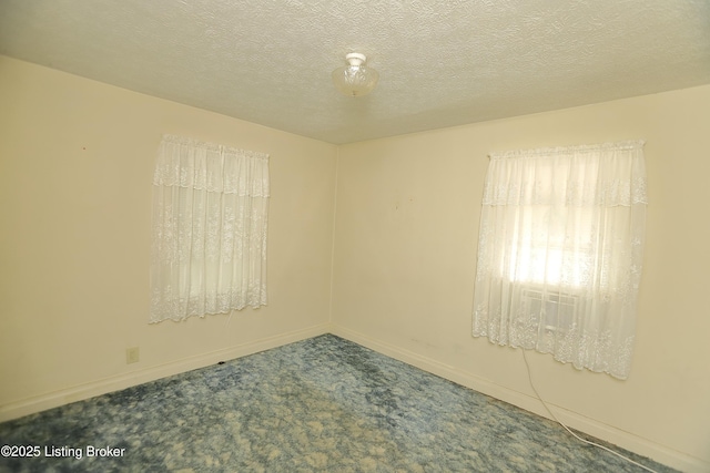 unfurnished room with baseboards, a textured ceiling, and carpet
