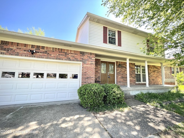 traditional home with driveway, covered porch, brick siding, and a garage