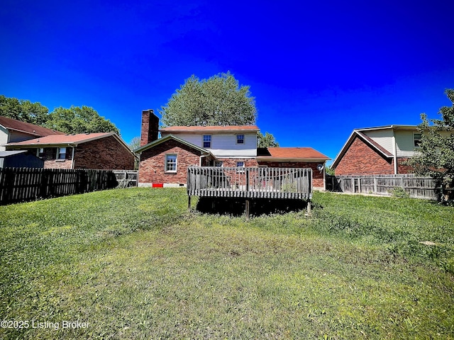 rear view of property featuring fence, a wooden deck, a chimney, and brick siding