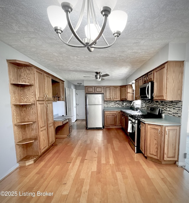 kitchen featuring decorative backsplash, open shelves, light wood-style floors, appliances with stainless steel finishes, and a textured ceiling