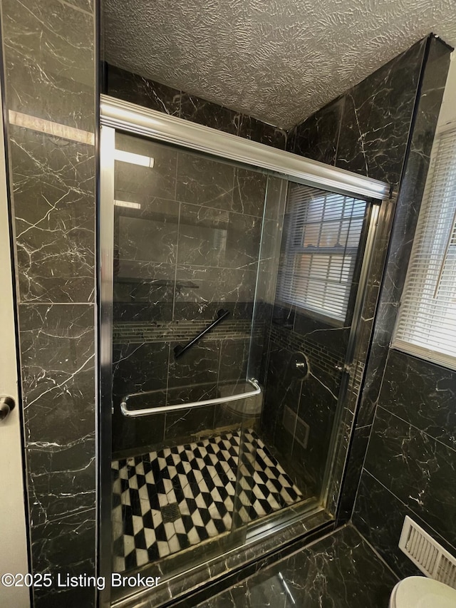 full bath featuring a shower stall and toilet
