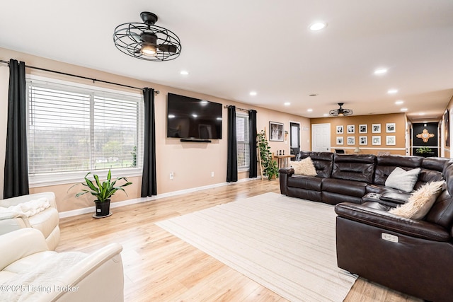 living area featuring wood finished floors, a ceiling fan, recessed lighting, and baseboards