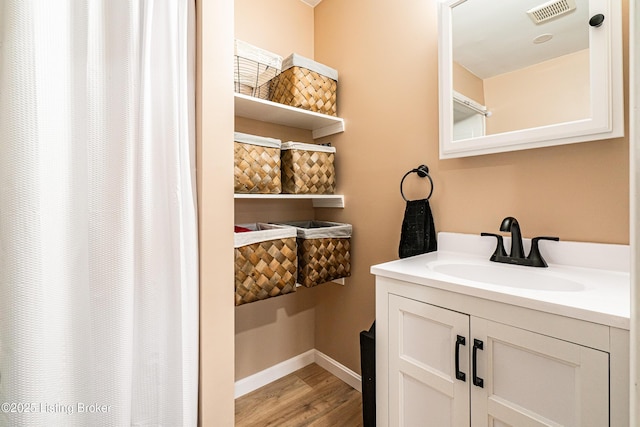 full bathroom featuring baseboards, visible vents, wood finished floors, and vanity