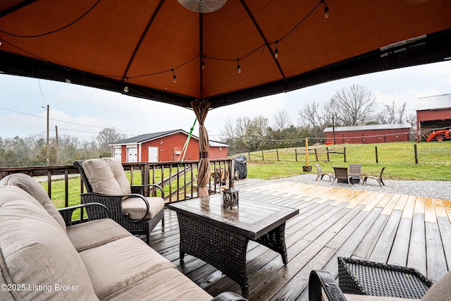 deck featuring outdoor lounge area, fence, and a yard
