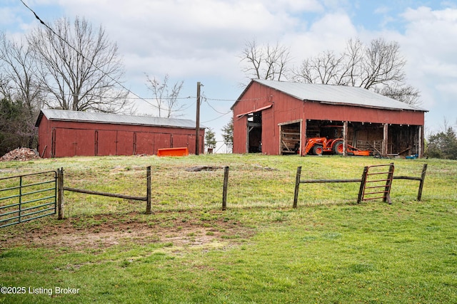 view of pole building with fence and a lawn