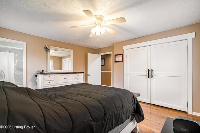 bedroom featuring a textured ceiling, light wood-style floors, a ceiling fan, and a closet