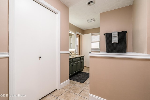 bathroom featuring tile patterned flooring, visible vents, vanity, and a textured ceiling