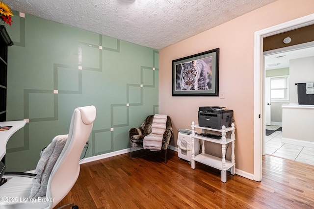 office area featuring a textured ceiling, wood finished floors, and baseboards