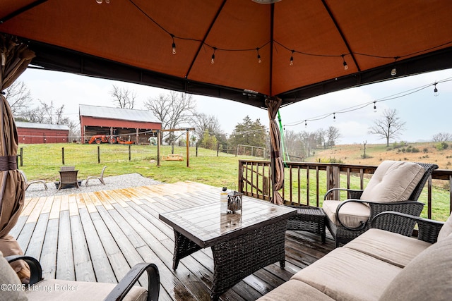 wooden deck featuring a lawn, a gazebo, an outdoor hangout area, and fence