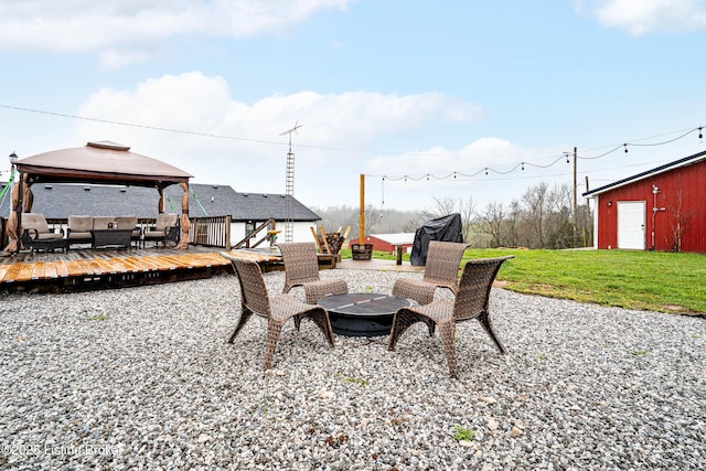 view of patio featuring a deck, a gazebo, and an outdoor living space with a fire pit