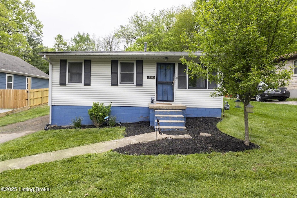bungalow-style house featuring a front lawn and fence