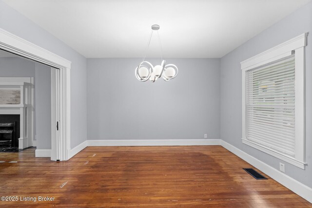 415 Gwendolyn St, Louisville, KY 40203 - unfurnished dining area featuring a chandelier, baseboards, and wood finished floors