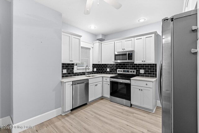 415 Gwendolyn St, Louisville, KY 40203 - kitchen featuring stainless steel appliances, a sink, light countertops, light wood-style flooring, and recessed lighting