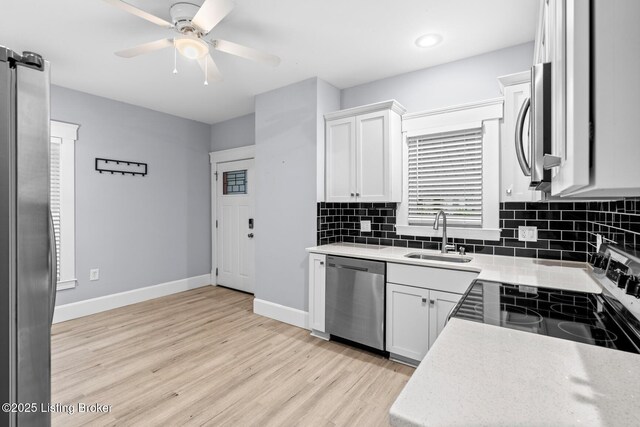 415 Gwendolyn St, Louisville, KY 40203 - kitchen featuring stainless steel appliances, a sink, light wood finished floors, a ceiling fan, and tasteful backsplash