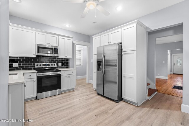 415 Gwendolyn St, Louisville, KY 40203 - kitchen with appliances with stainless steel finishes, baseboards, light wood-style floors, decorative backsplash, and recessed lighting