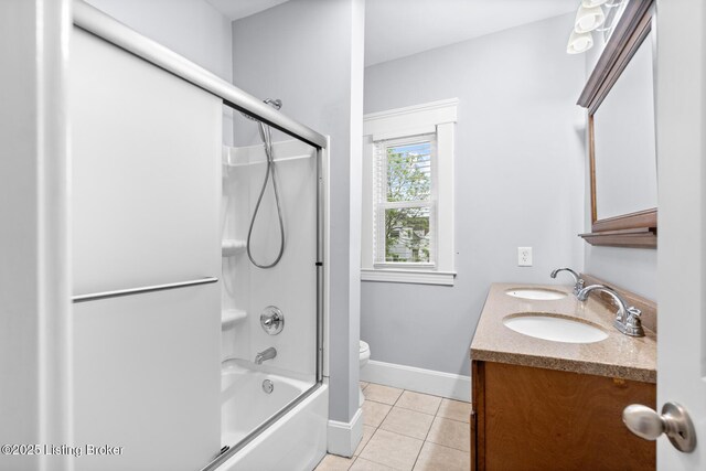 415 Gwendolyn St, Louisville, KY 40203 - full bathroom featuring tile patterned floors, toilet, double vanity, combined bath / shower with glass door, and baseboards