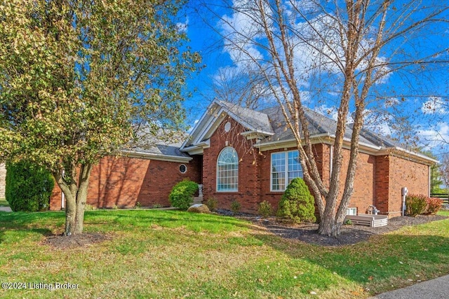 view of front of property with a front yard and brick siding