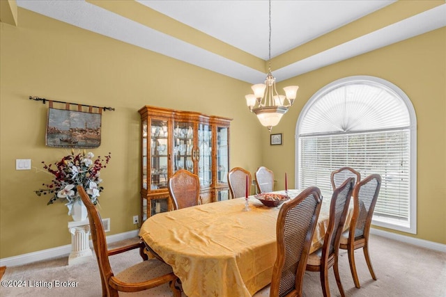 dining space featuring an inviting chandelier, a wealth of natural light, baseboards, and light carpet