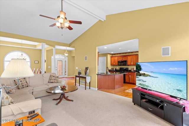 living room with light colored carpet, beamed ceiling, ceiling fan, visible vents, and high vaulted ceiling