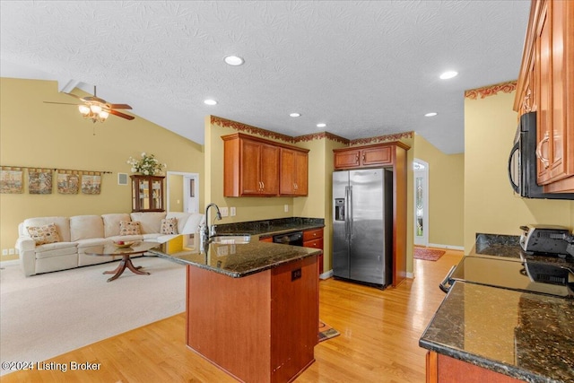 kitchen with a sink, ceiling fan, black appliances, a peninsula, and open floor plan