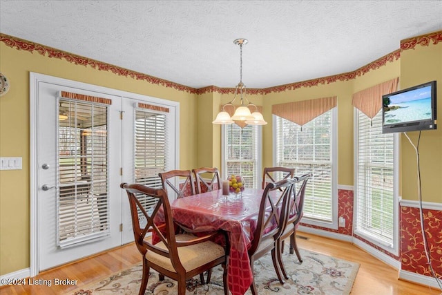 dining space with light wood-style flooring, a wealth of natural light, and baseboards