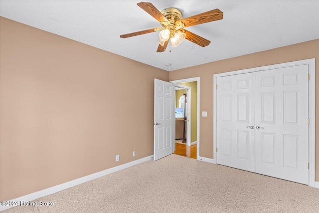 unfurnished bedroom with a closet, a ceiling fan, carpet floors, and baseboards