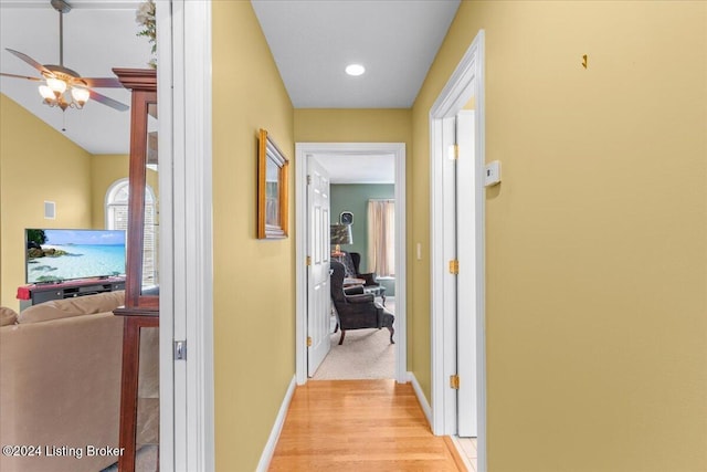 corridor featuring baseboards, recessed lighting, and light wood-style flooring