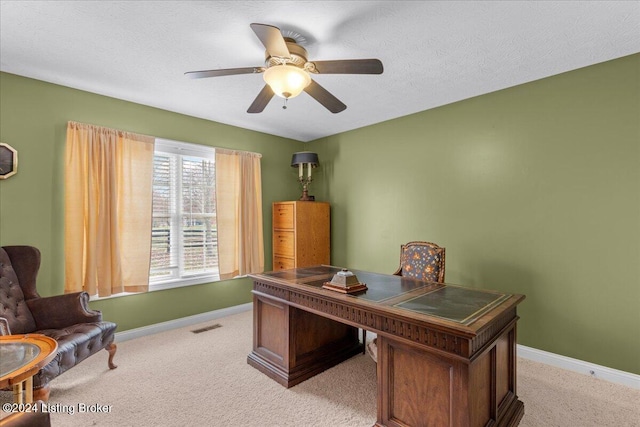 home office with a ceiling fan, visible vents, light carpet, and baseboards