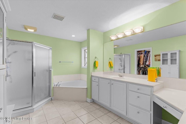 bathroom featuring vanity, a bath, tile patterned floors, a stall shower, and visible vents