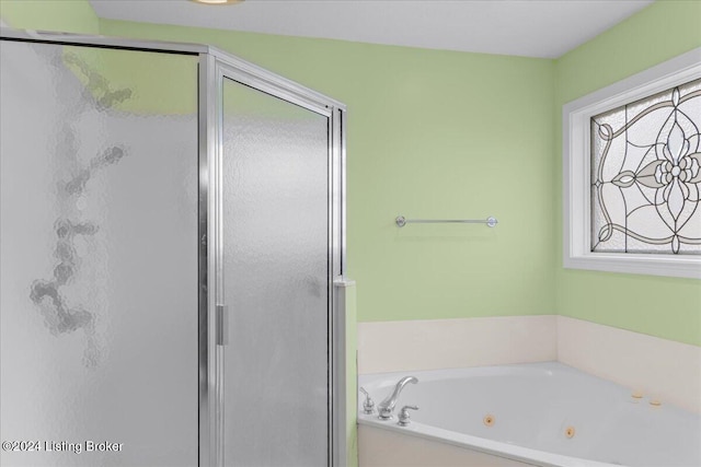 bathroom with a jetted tub and a stall shower