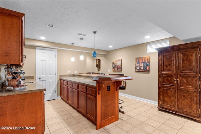 kitchen featuring a breakfast bar area, visible vents, a peninsula, and recessed lighting