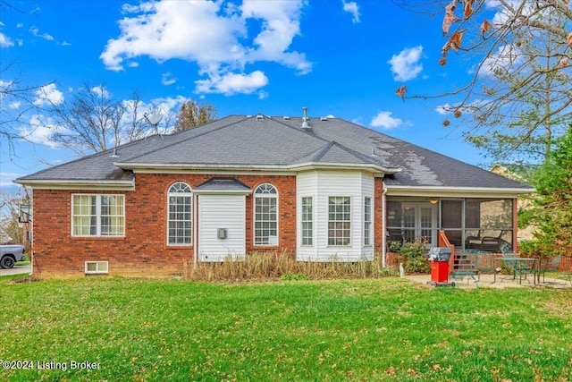back of house with brick siding, a yard, a sunroom, and a patio area