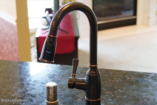 room details featuring dark stone counters and a sink