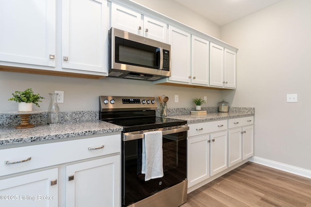1332 Etawah Ave, Louisville, KY 40222 - kitchen featuring stainless steel appliances, white cabinets, light wood finished floors, baseboards, and light stone counters