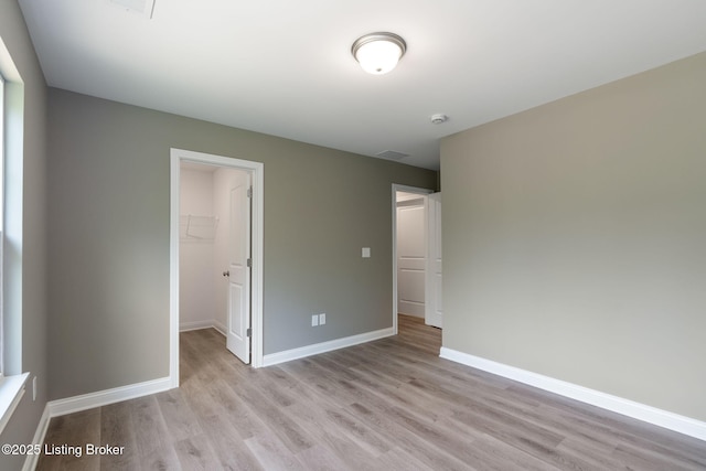 1332 Etawah Ave, Louisville, KY 40222 - unfurnished bedroom featuring light wood-style floors, a spacious closet, baseboards, and a closet