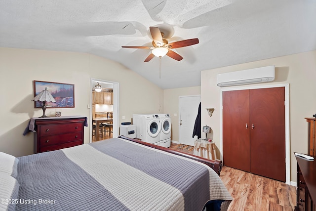 117 Fairview Dr, Waddy, KY 40076 - bedroom with a ceiling fan, vaulted ceiling, an AC wall unit, washer and dryer, and wood finished floors