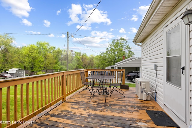 117 Fairview Dr, Waddy, KY 40076 - wooden deck featuring outdoor dining space, a yard, a storage shed, and an outdoor structure
