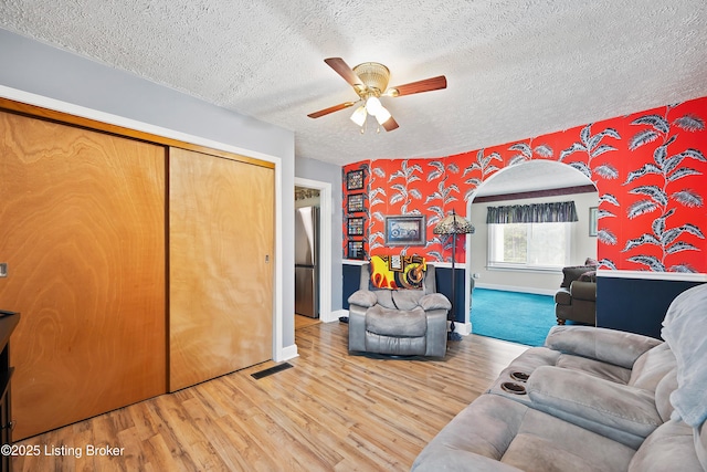 117 Fairview Dr, Waddy, KY 40076 - living area featuring a textured ceiling, visible vents, arched walkways, wood finished floors, and a ceiling fan