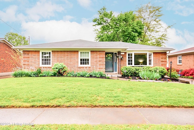 ranch-style house featuring brick siding and a front yard