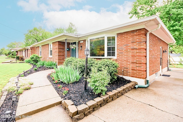ranch-style home with a front yard and brick siding