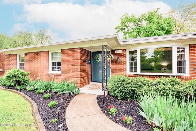entrance to property featuring brick siding