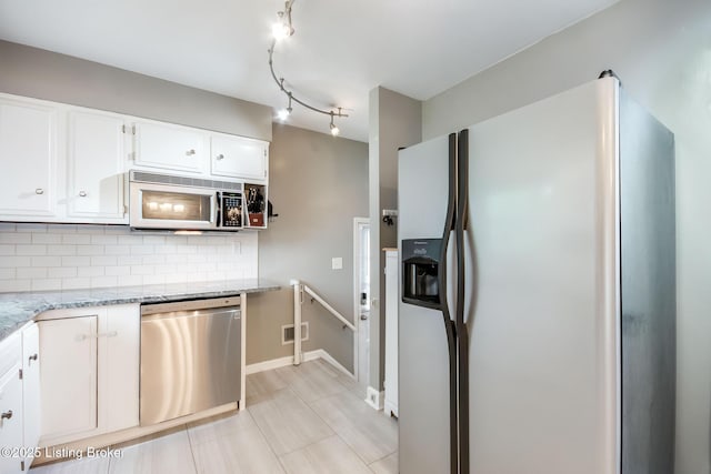 kitchen featuring tasteful backsplash, light stone counters, appliances with stainless steel finishes, white cabinetry, and visible vents