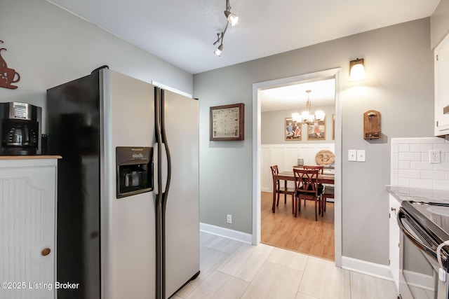 kitchen with white cabinetry, light countertops, electric stove, a notable chandelier, and stainless steel fridge with ice dispenser
