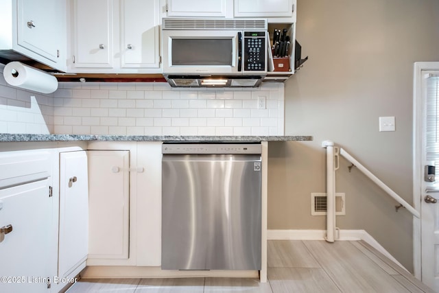 kitchen featuring visible vents, stainless steel appliances, backsplash, and white cabinets