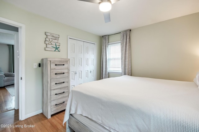 bedroom with a ceiling fan, light wood-style flooring, baseboards, and a closet