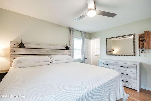 bedroom with baseboards, ceiling fan, and light wood-style flooring