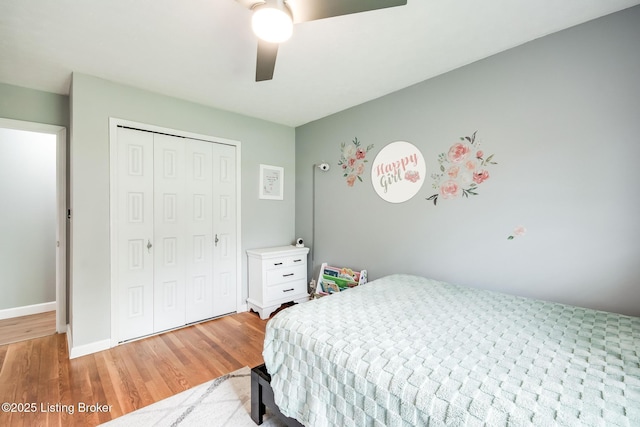 bedroom with baseboards, a ceiling fan, a closet, and light wood finished floors